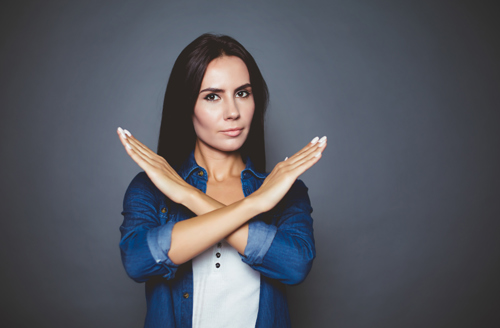 women making a cross sign with her hands