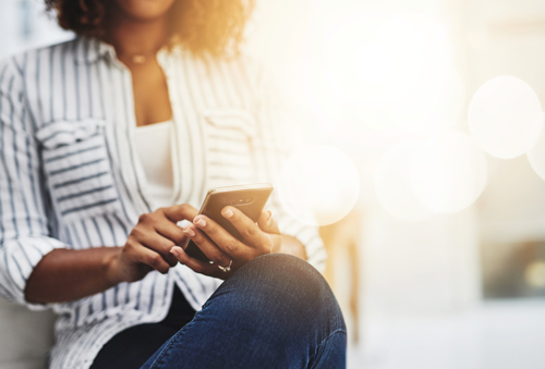 person looking at her phone about the fcdo travel advice