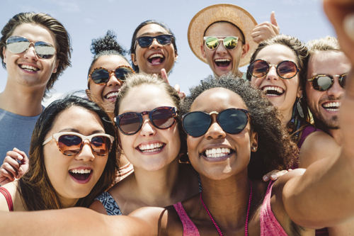 group of people wearing sunglasses taking a phone together